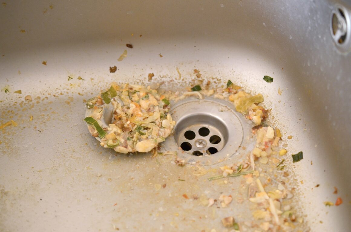 Close up on dirty clogging kitchen sink drain with food particles