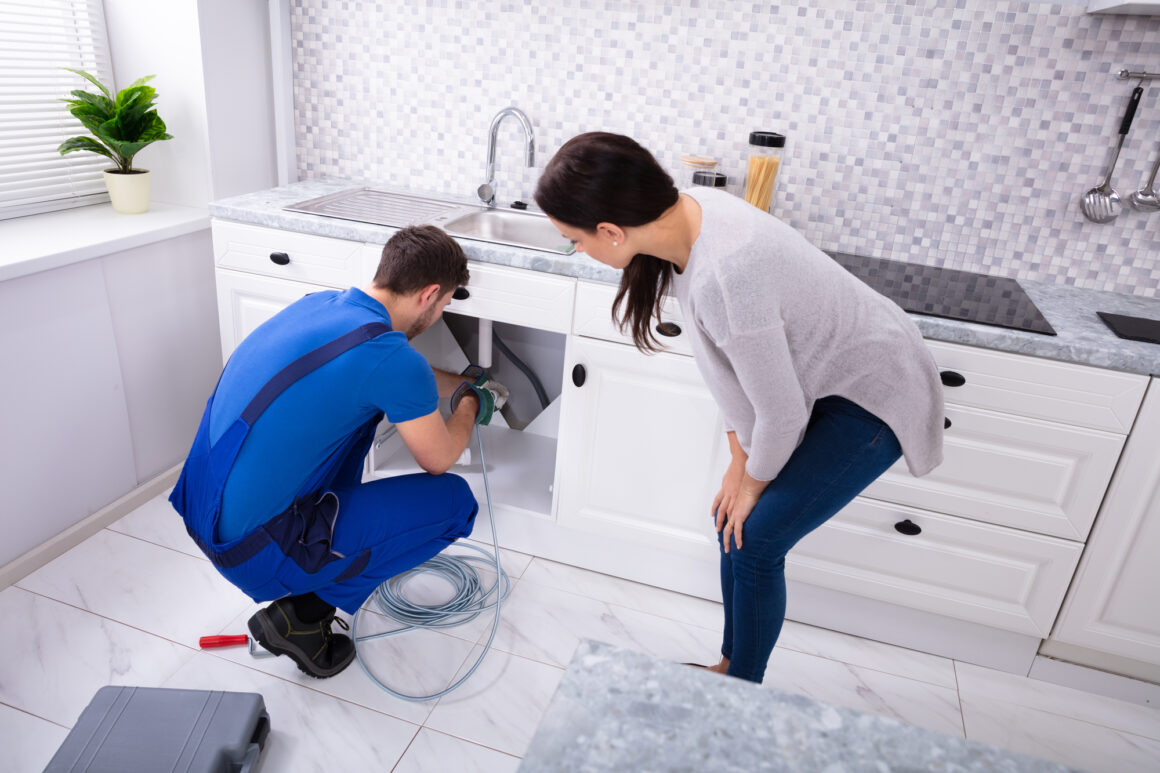 Male Plumber Cleaning Clogged Sink Pipe With Drained Cable Daly City